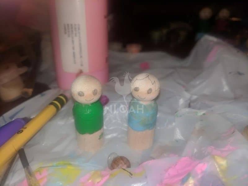 drawing hair on wooden peg dolls