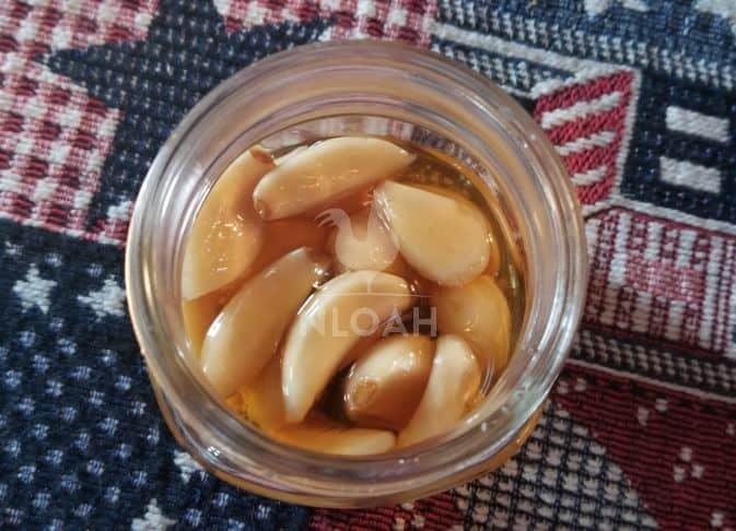 open jar of garlic-infused honey
