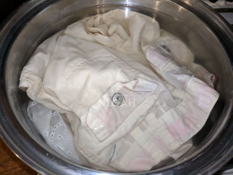 fabric soaking in a mordant bath on the stove