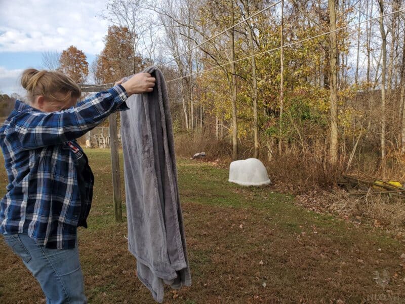 folding a blanket over a clothesline