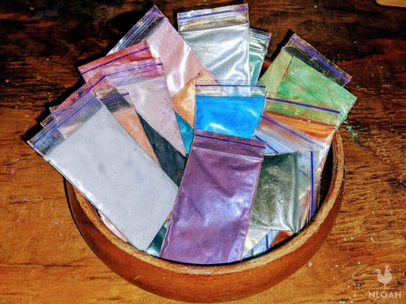 packs of colored mica powder in wooden bowl