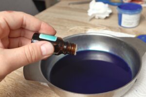 adding essential oil to mica powder and melted wax mix