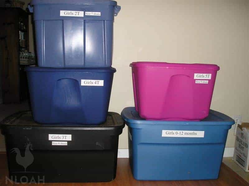 plastic containers filled with kids clothes