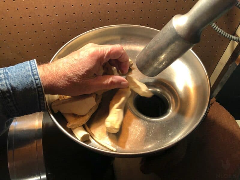 grinding horseradish in a large grinder
