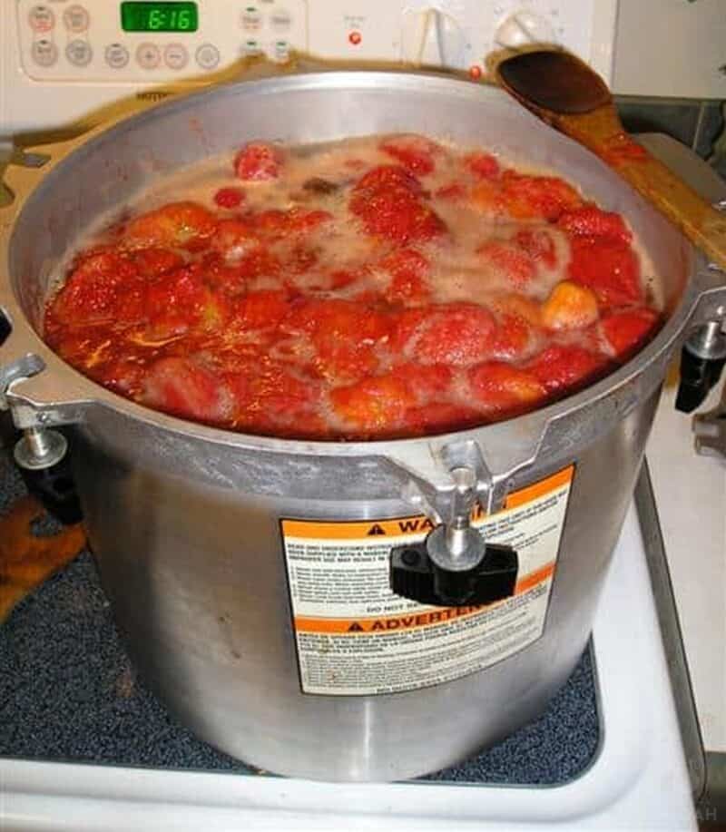 cooking a large batch of tomatoes on stovetop