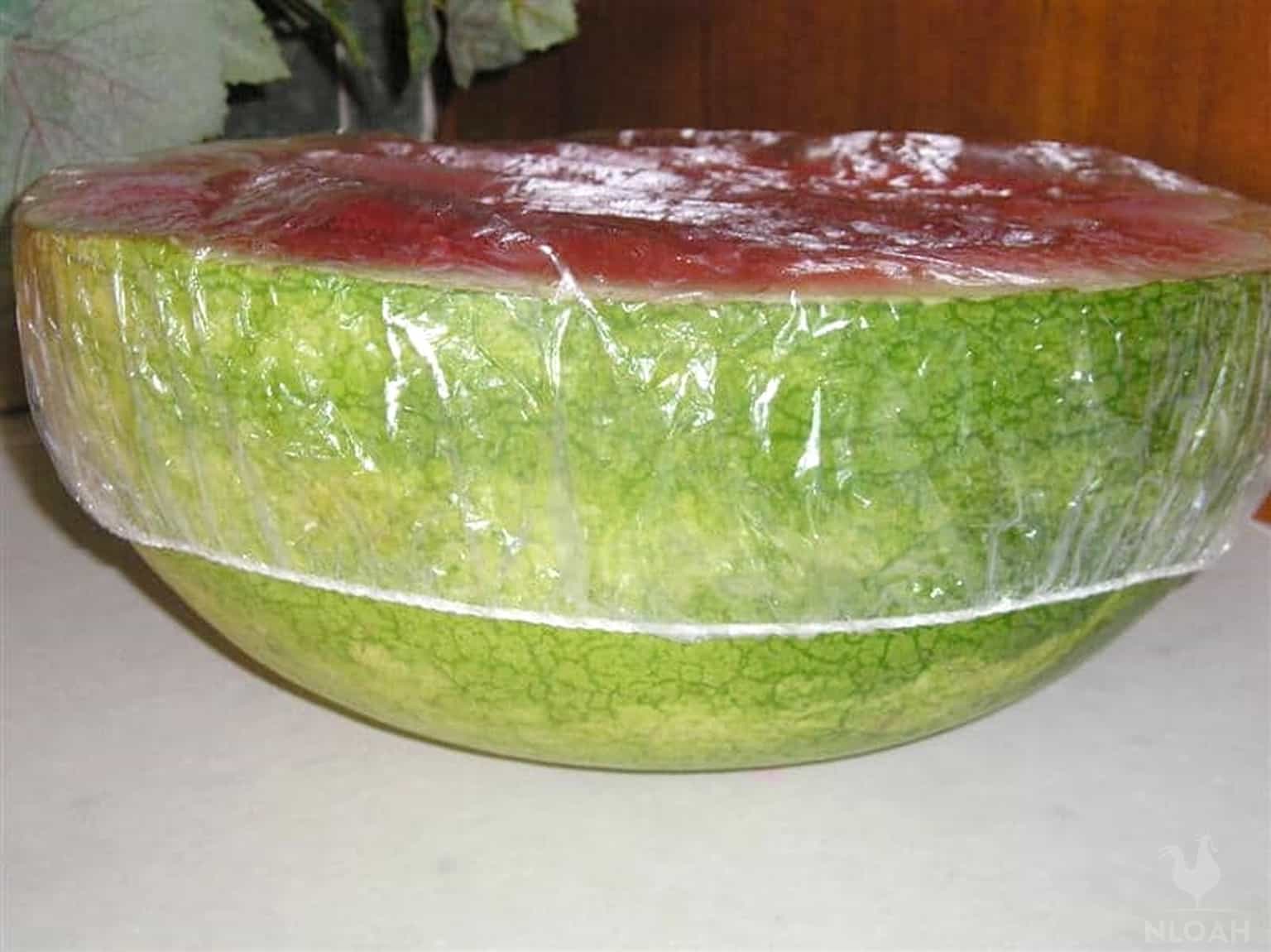 half a watermelon covered with plastic shower cap