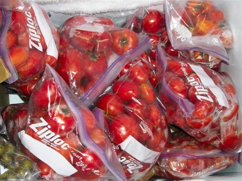 zipper bags of frozen tomatoes inside freezer