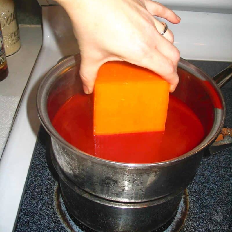 dipping cheese in wax by hand