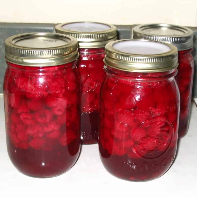 four jars of canned raspberries