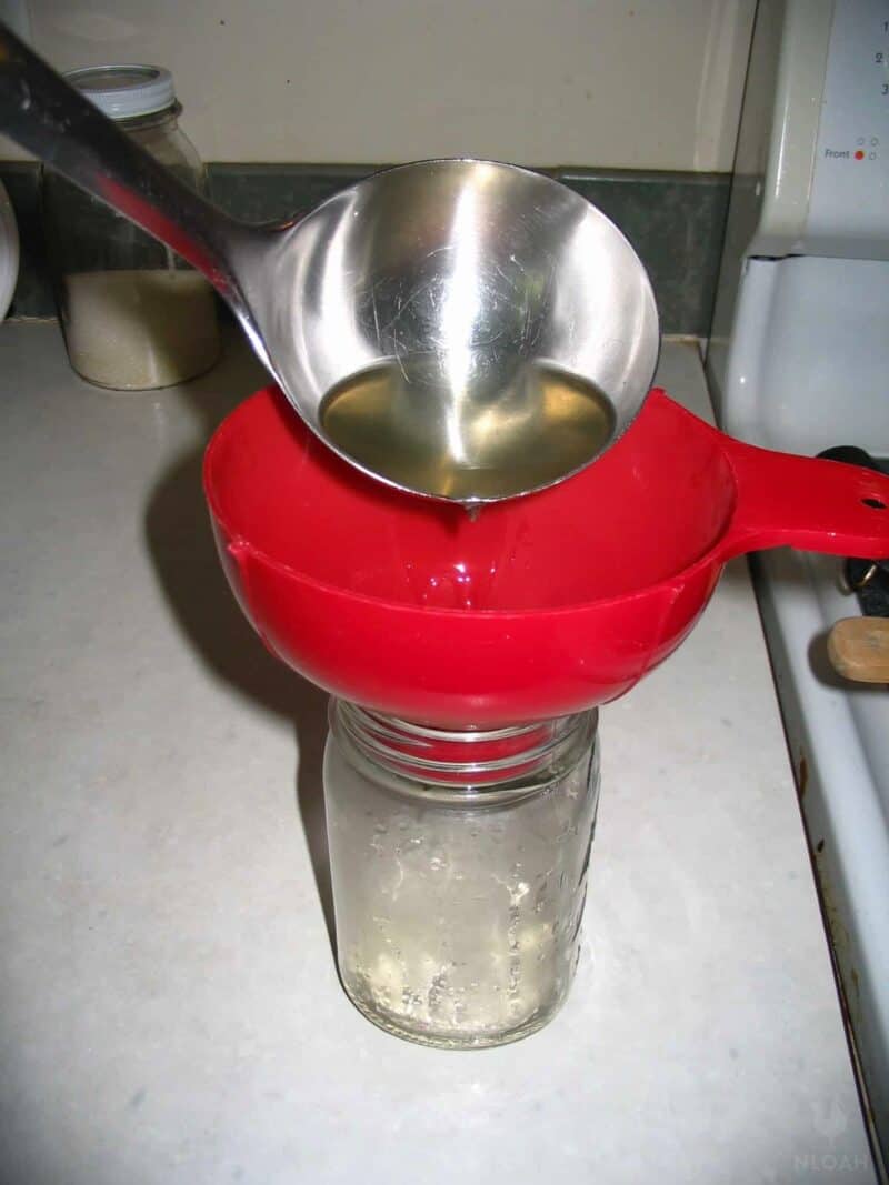 ladling hot syrup into jar