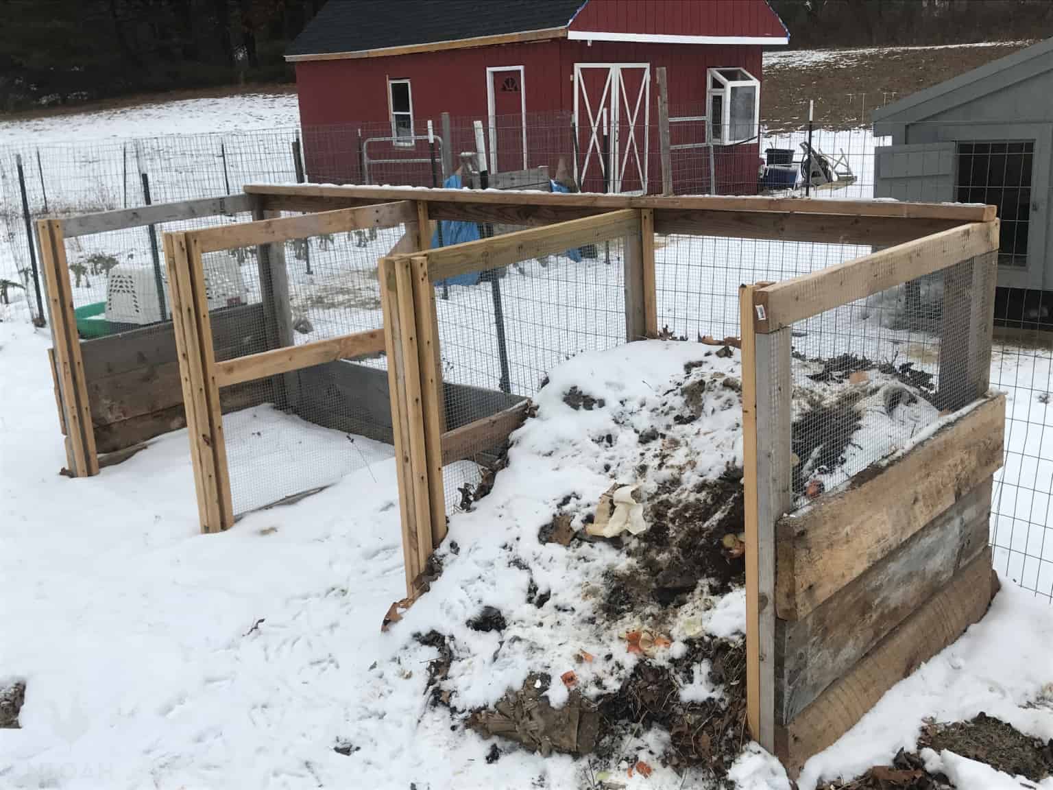 a 3-bin composter made of scrap wood and wire mesh on the winter homestead