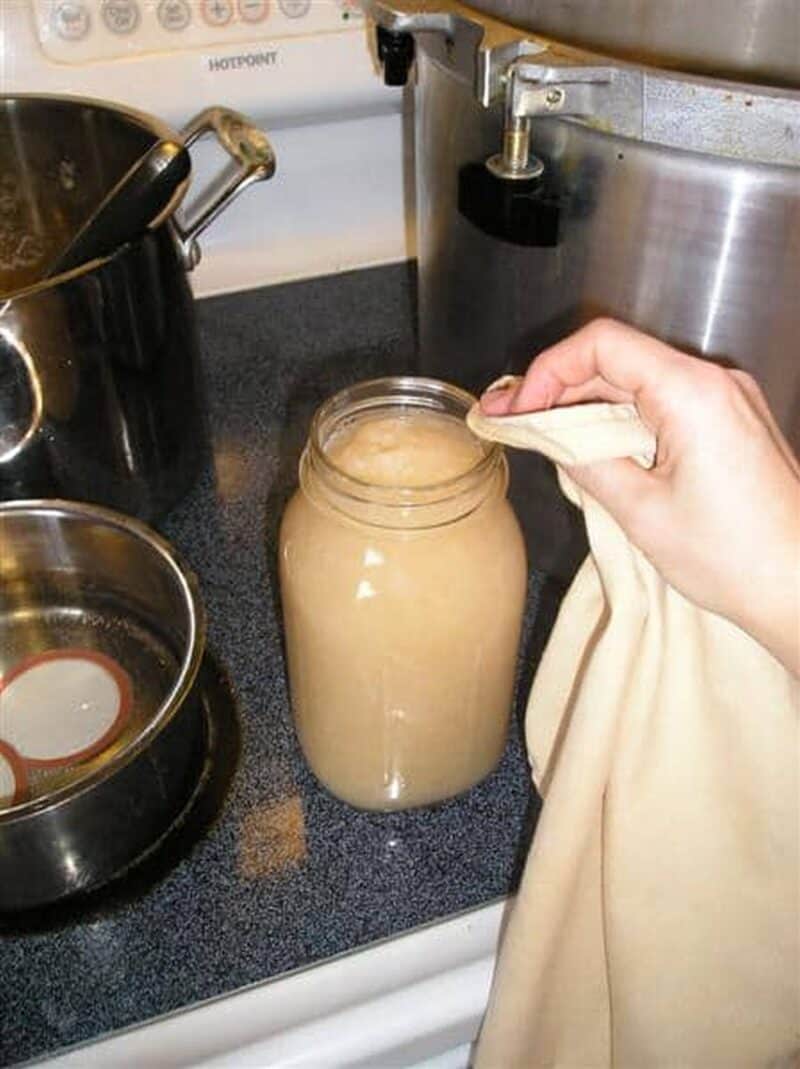 cleaning jar with pear sauce with a wet rag