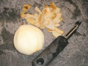 peeled pear next to peels and peeler