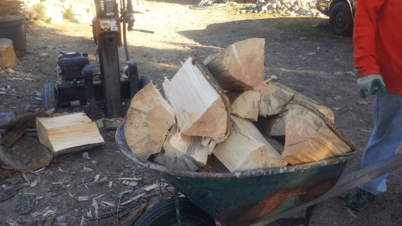 a wheelbarrow full of split wood