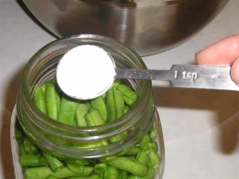 adding salt in canning jar with green beans