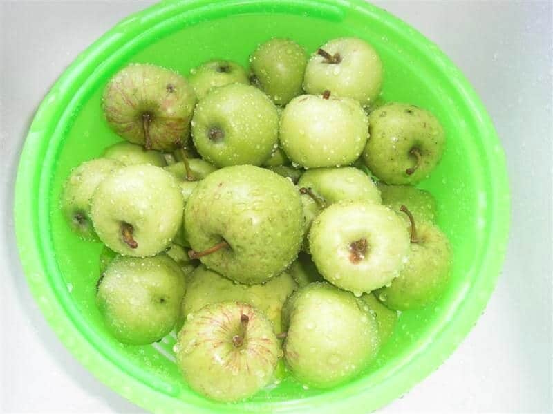 apples submerged in water in plastic container