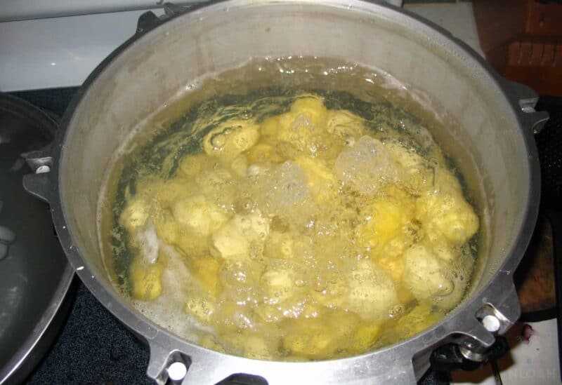 peeled whole potatoes boiling in water
