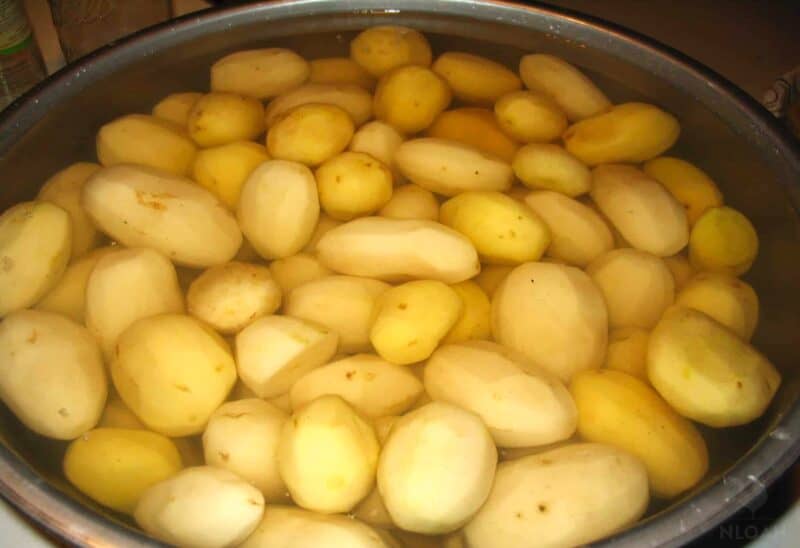 peeled whole potatoes in  old water