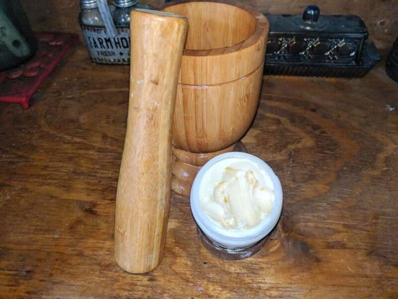 jar of cocoa butter next to wooden mortar  and pestle