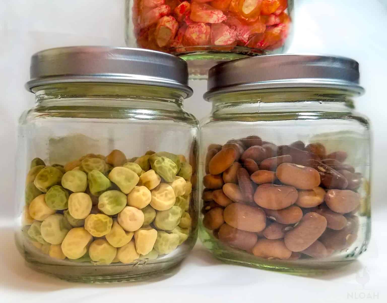 peas and beans seeds in glass jars