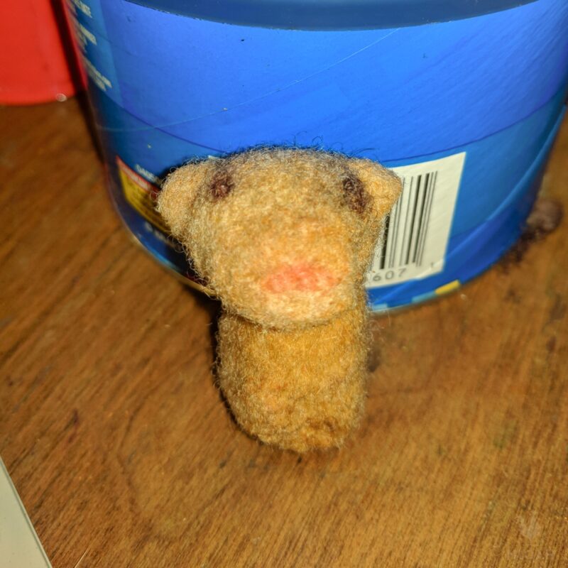 head and body of a tiny needle felted bear