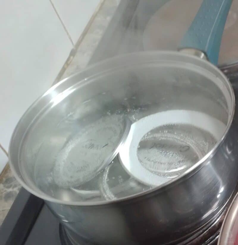 canning lids on boiling water on stove