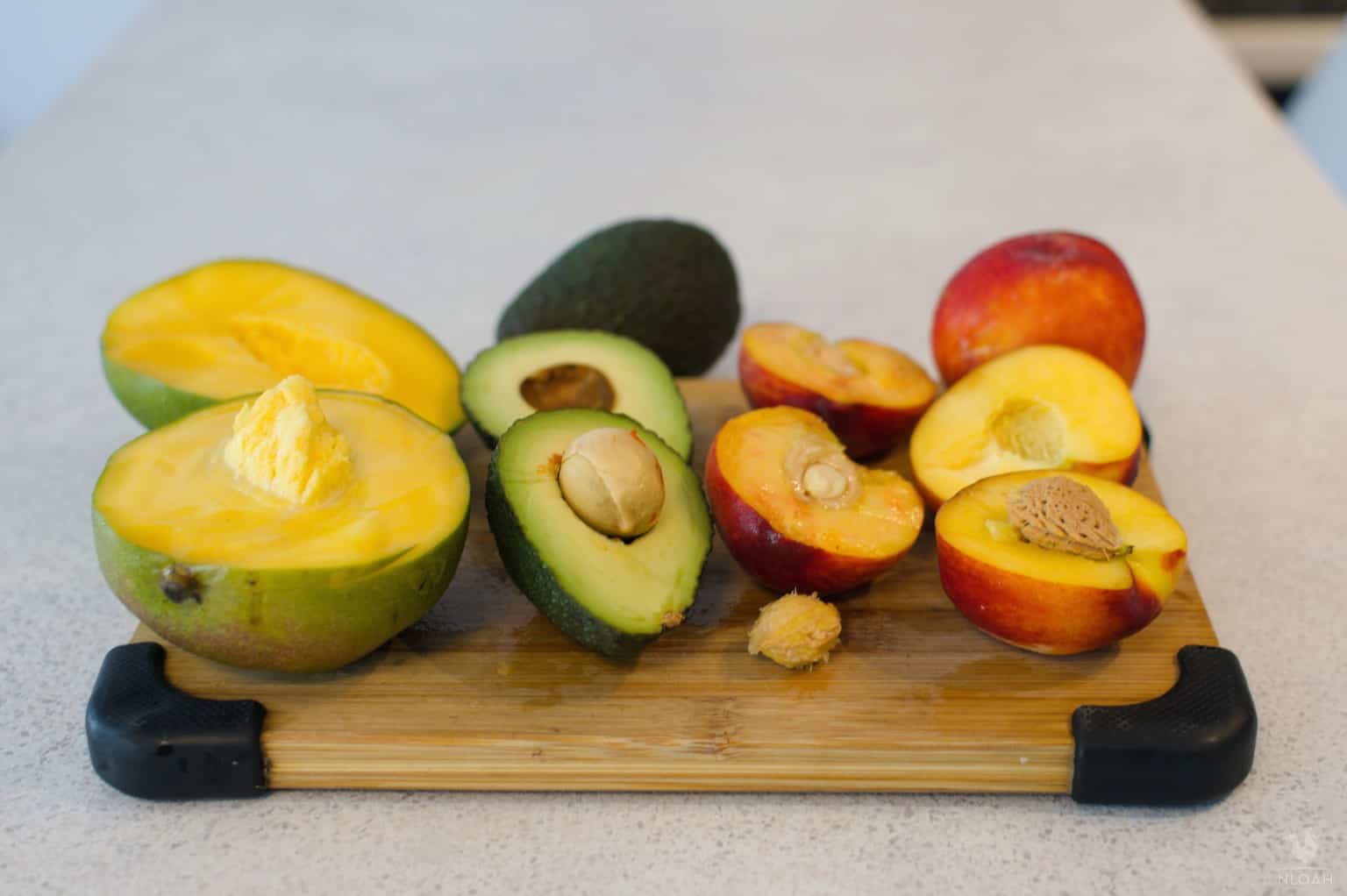 mango avocado peaches and nectarines next to their seeds