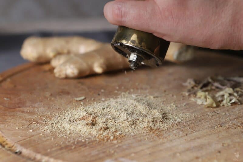 grinding baked ginger root into powder