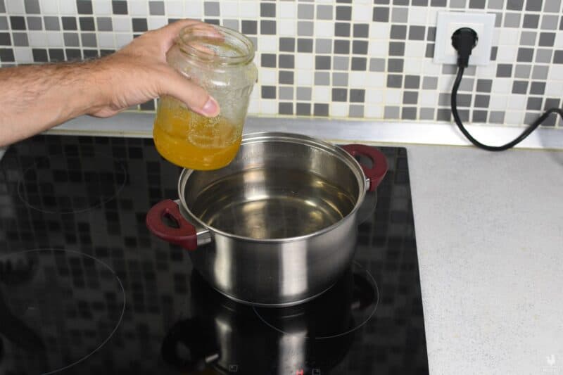 placing jar of honey in boiling water