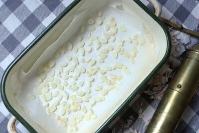 sliced garlic in oven tray on baking sheet