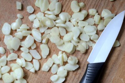 sliced garlic next to paring knife