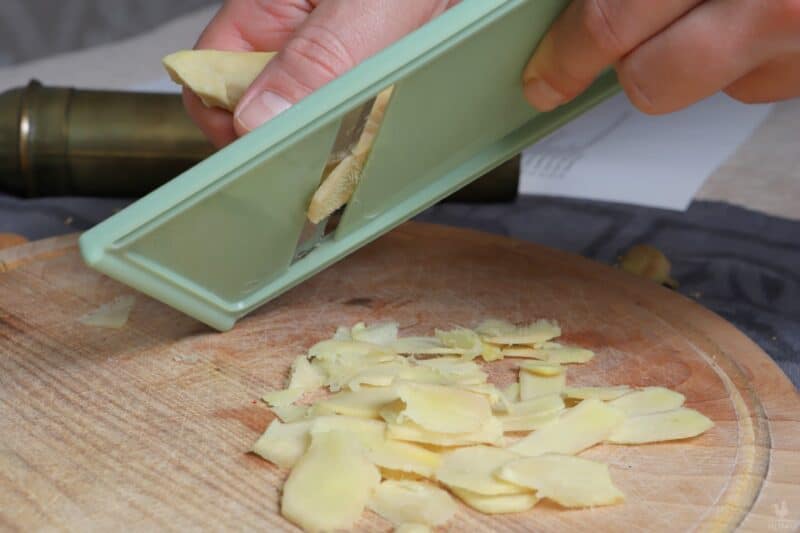 slicing ginger root with grater