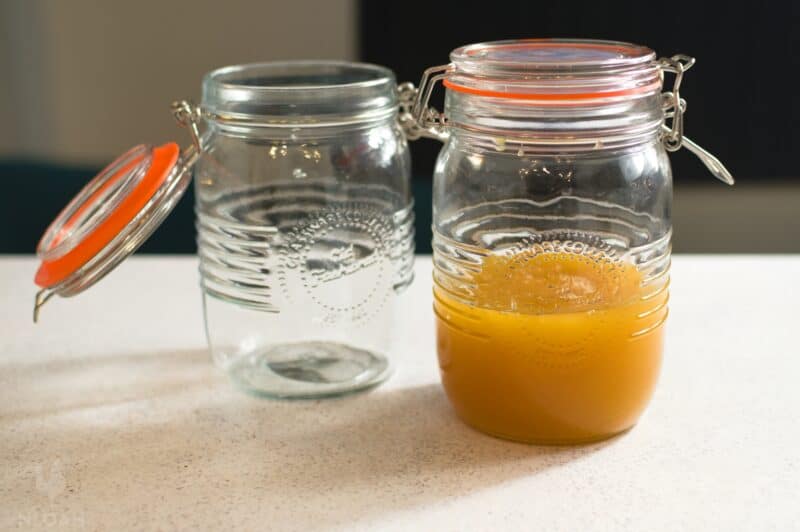 Airtight jar with honey and another one that's empty.