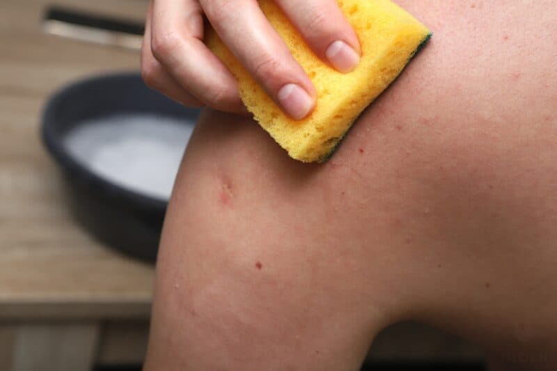 washing shoulder with sponge