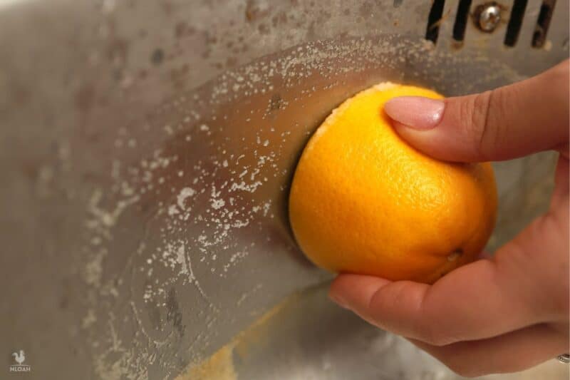 cleaning sink with half an orange and salt